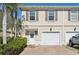 Inviting townhome featuring a one-car garage, brick driveway, and lush landscaping for enhanced curb appeal at 1555 Napoli W Dr, Sarasota, FL 34232