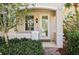 Charming front entrance with a glass-paneled door, stylish light fixture, and verdant landscaping at 1555 Napoli W Dr, Sarasota, FL 34232