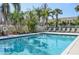 Sparkling community pool with comfortable lounge chairs and lush tropical landscaping at 1555 Napoli W Dr, Sarasota, FL 34232