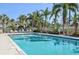 Inviting community pool surrounded by well-maintained landscaping and comfortable lounge chairs at 1555 Napoli W Dr, Sarasota, FL 34232