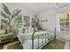 Stylish bedroom featuring a green metal frame bed with leafy green decor and natural lighting at 1609 1St W Ave, Bradenton, FL 34205