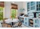 Close-up of a well-lit kitchen and dining area with blue cabinets and stainless steel appliances at 1609 1St W Ave, Bradenton, FL 34205