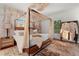 Stylish main bedroom with a four-poster bed, natural light, and light color tones at 1609 1St W Ave, Bradenton, FL 34205