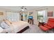 Bright bedroom features two windows, ceiling fan, neutral walls, television, and comfortable seating at 1612 Pine Harrier Cir, Sarasota, FL 34231