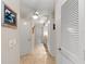 Hallway leading to bathroom showcases tile flooring, ceiling fan, and neutral walls at 1612 Pine Harrier Cir, Sarasota, FL 34231