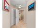 Hallway leading to the bathroom showcases tile flooring, ceiling fan, and neutral walls at 1612 Pine Harrier Cir, Sarasota, FL 34231