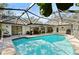 Gorgeous pool with screened enclosure, surrounded by mature landscaping and a brick patio at 1612 Pine Harrier Cir, Sarasota, FL 34231