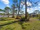 Spacious backyard with mature trees and a view of the home, offering a private and serene outdoor setting at 1627 Bayshore Dr, Englewood, FL 34223