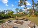 Cozy backyard firepit surrounded by chairs and greenery; perfect for entertaining at 1627 Bayshore Dr, Englewood, FL 34223