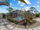 Beautiful backyard with stone walkway leading to the screened-in pool area at 1627 Bayshore Dr, Englewood, FL 34223