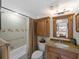 Bathroom featuring shower-tub combo, neutral tile and a vanity with tan granite countertop at 1627 Bayshore Dr, Englewood, FL 34223