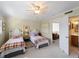 Bedroom with two twin beds, ceiling fan, neutral walls, and access to ensuite bathroom at 1627 Bayshore Dr, Englewood, FL 34223