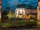 Eye-catching A-frame home with distinctive architecture and a manicured lawn, illuminated against the twilight sky at 1627 Bayshore Dr, Englewood, FL 34223