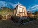 Well-lit, contemporary A-frame home with floor to ceiling windows, a porch, and manicured landscaping at twilight at 1627 Bayshore Dr, Englewood, FL 34223