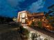 Modern home with unique architecture and a wall of glass, complemented by landscaped grounds and exterior lighting at dusk at 1627 Bayshore Dr, Englewood, FL 34223