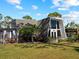 A unique A-frame home with manicured lawn, featuring outdoor sitting and garden, creating a serene and inviting space at 1627 Bayshore Dr, Englewood, FL 34223