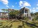 An exterior view of an A-frame home with a well-manicured lawn and a covered outdoor seating area at 1627 Bayshore Dr, Englewood, FL 34223