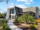 This home features unique architecture, complemented by verdant landscaping and a stone pathway leading to the entrance at 1627 Bayshore Dr, Englewood, FL 34223