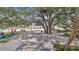 Outdoor community space with large shade tree and a deck with seating areas at 19715 Tortuga Cay Dr, Venice, FL 34293