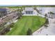 Wide view of the community clubhouse with a large manicured lawn and waterfront at 19715 Tortuga Cay Dr, Venice, FL 34293