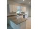 Bright kitchen featuring granite countertops, white cabinets, and a stainless steel dishwasher at 19715 Tortuga Cay Dr, Venice, FL 34293