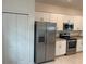 View of the kitchen featuring stainless steel appliances, a large refrigerator, and white cabinets at 19715 Tortuga Cay Dr, Venice, FL 34293