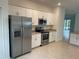 View of the kitchen with stainless steel appliances, granite countertops, and adjacent dining area at 19715 Tortuga Cay Dr, Venice, FL 34293