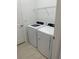 Laundry room equipped with a modern white washer and dryer set and a wire shelf at 19715 Tortuga Cay Dr, Venice, FL 34293