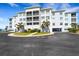 Exterior of a condo with balconies and a well-manicured lawn and palm trees at 2001 Bal Harbor Blvd # 2301, Punta Gorda, FL 33950