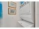 Modern white stackable washer and dryer in laundry area with wall art at 2001 Bal Harbor Blvd # 2301, Punta Gorda, FL 33950