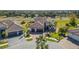 Aerial view of a home with a tile roof, manicured lawn, and a three-car garage at 20078 Elegante Ct, Venice, FL 34293