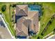 An aerial view shows a beautiful home with tile roofing and a screened-in pool at 20078 Elegante Ct, Venice, FL 34293