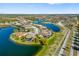 Beautiful aerial view of a lakeside home with a lush landscaped yard in a vibrant community at 20078 Elegante Ct, Venice, FL 34293