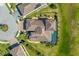 Overhead view of a tile roof home, screened in pool, lush green yard, and long driveway at 20078 Elegante Ct, Venice, FL 34293