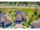 Aerial view of lush lawn with a beautiful tile roof home and screened in pool at 20078 Elegante Ct, Venice, FL 34293