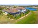 Aerial view of the home's backyard with a screened-in pool and lush landscaping overlooking the water at 20078 Elegante Ct, Venice, FL 34293