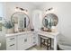 Dual vanity with marble countertops, round mirrors, and modern lighting in the bathroom at 20078 Elegante Ct, Venice, FL 34293