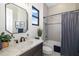 Bright bathroom featuring a marble countertop, black fixtures, and a shower with gray tile surround at 20078 Elegante Ct, Venice, FL 34293