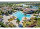 Aerial shot of community pool with many lounge chairs, dining, palm trees and beautiful landscaping at 20078 Elegante Ct, Venice, FL 34293