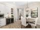 Dining area with a round wooden table, white chairs, a wine refrigerator, and a view of the staircase at 20078 Elegante Ct, Venice, FL 34293