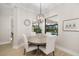 Charming dining room features a round wooden table and four upholstered chairs, and backyard views at 20078 Elegante Ct, Venice, FL 34293