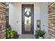 Inviting front door with decorative wreath, stone accents, and a charming welcome sign at 20078 Elegante Ct, Venice, FL 34293