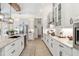 Bright kitchen featuring white cabinets, stainless appliances and a light stone backsplash with a view of the home at 20078 Elegante Ct, Venice, FL 34293