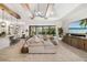 Bright living room with a large sectional sofa, wooden beams, and sliding glass doors to the backyard at 20078 Elegante Ct, Venice, FL 34293