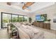 Cozy living room with large sectional sofa, stylish furniture, and sliding glass doors to the outdoor pool at 20078 Elegante Ct, Venice, FL 34293