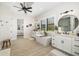 Bright main bathroom featuring a soaking tub, dual vanities and access to the main bedroom and shower at 20078 Elegante Ct, Venice, FL 34293