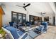 Covered patio seating area with comfortable chairs, a ceiling fan, and access to the outdoor kitchen at 20078 Elegante Ct, Venice, FL 34293