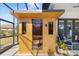 Exterior view of a wooden sauna on a patio, with nearby seating and lush landscaping at 20078 Elegante Ct, Venice, FL 34293