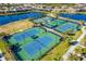 Aerial view of community tennis courts with lakes in the background and surrounding green landscaping at 20078 Elegante Ct, Venice, FL 34293