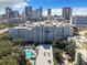 Condo building with rooftop parking and pool offering downtown skyline views from above the treeline at 201 W Laurel St # 209, Tampa, FL 33602